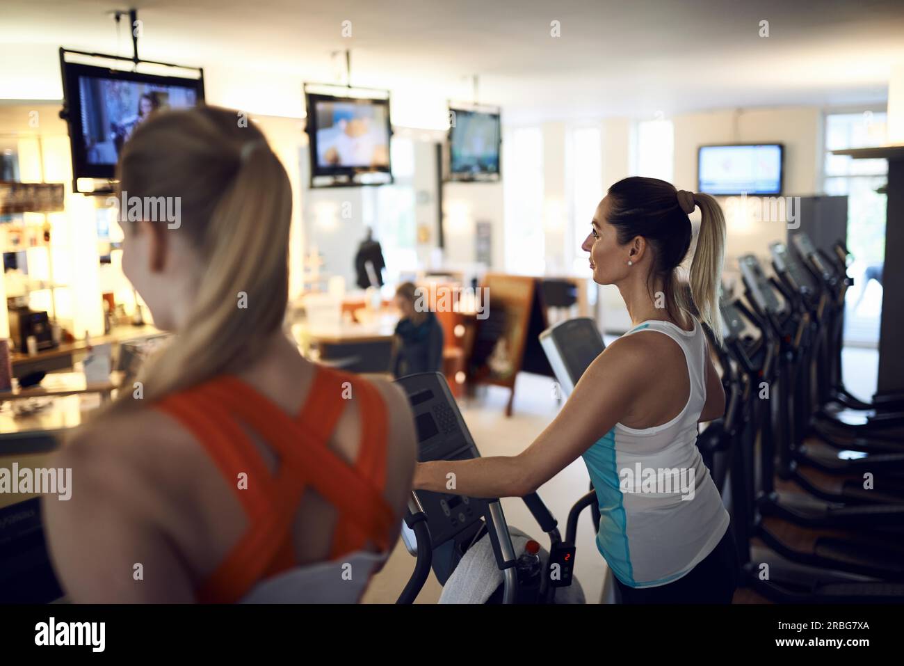 Seitenansicht der Frau mittleren Alters mit anaerobem Training Maschine im Fitness-Studio Stockfoto