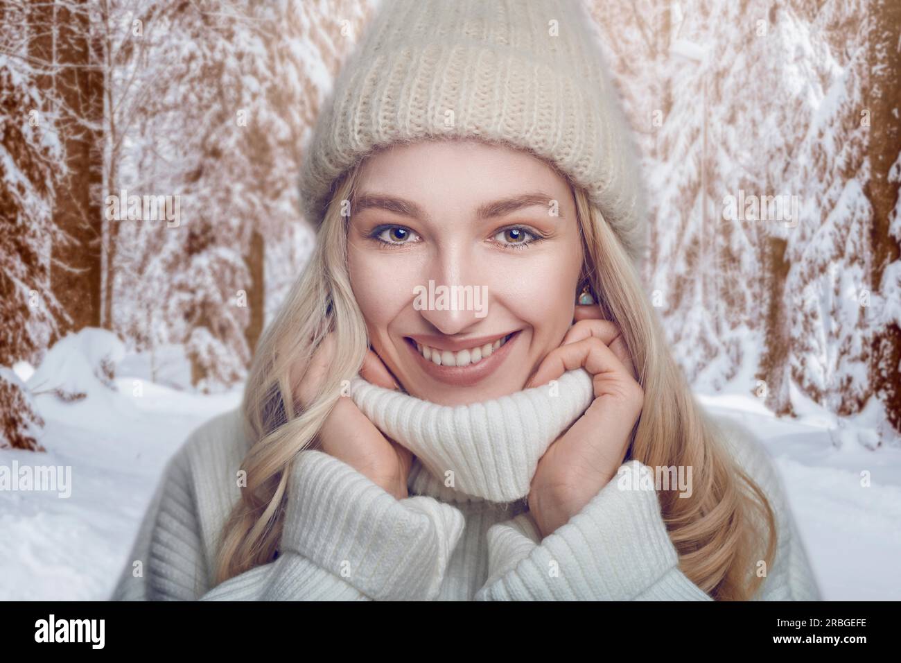 Eine attraktive blonde Frau in einem warmen Wollpullover mit Polokragen und Strickmütze, die sich im Freien mit einem fröhlichen Freund in den Kragen kuschelt Stockfoto