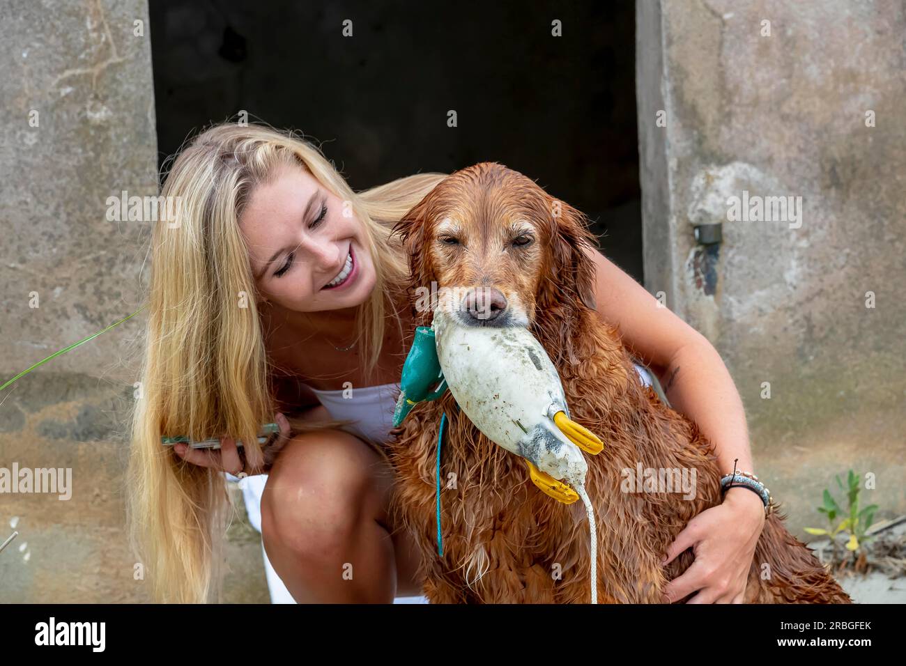 Ein hübsches blondes Model, das mit ihrem Hund posiert Stockfoto