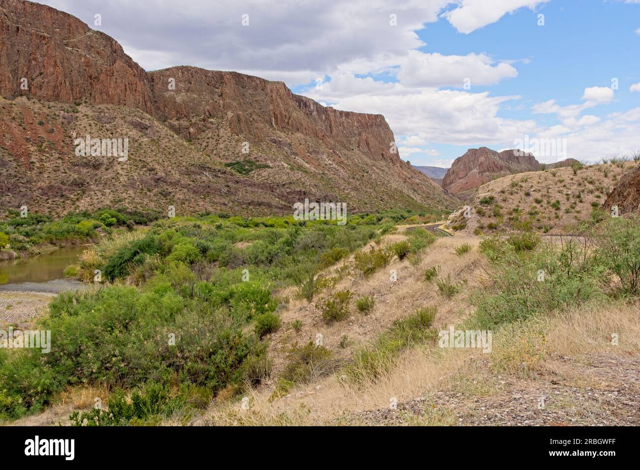 Der üppig grüne Rio Grande River und der zweispurige Highway führen durch mesa im Big Bend Ranch State Park Stockfoto
