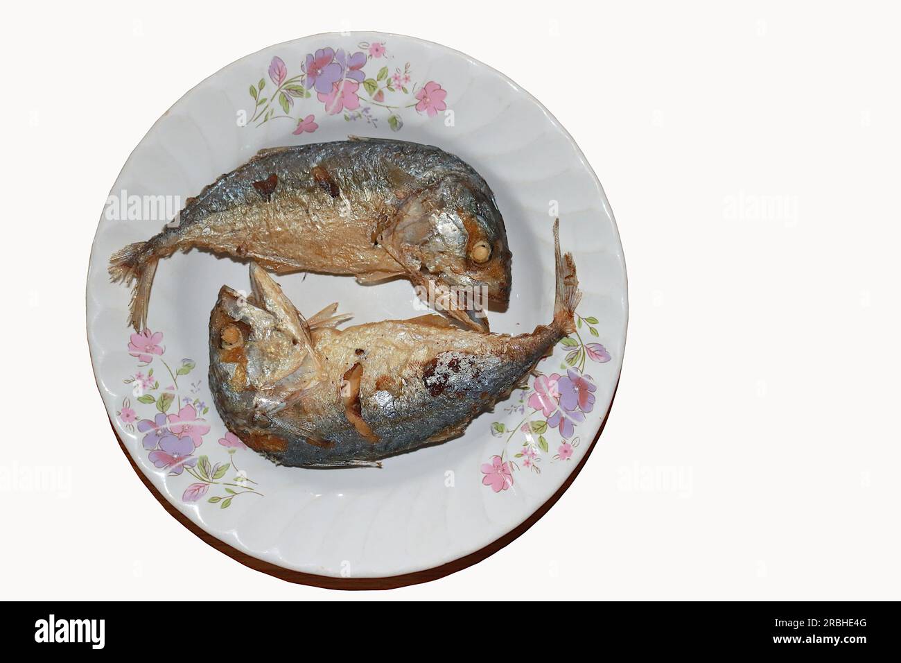 Zwei frittierte Makrelen werden abwechselnd mit Köpfen und Schwänzen auf einem Teller platziert. Stockfoto