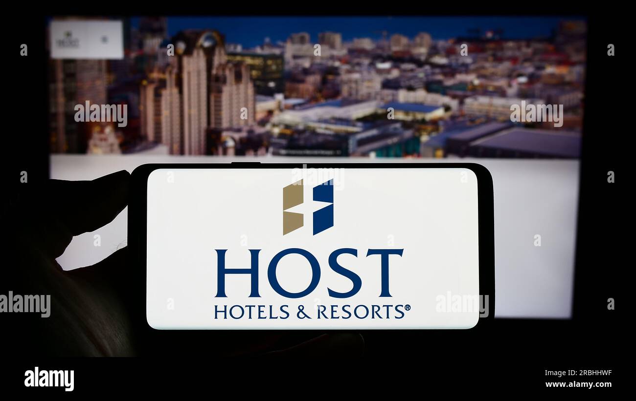 Person, die ein Smartphone mit dem Logo des US-Unternehmens Host Hotels and Resorts Inc. Auf dem Bildschirm vor der Website hält. Konzentrieren Sie sich auf das Display des Telefons. Stockfoto