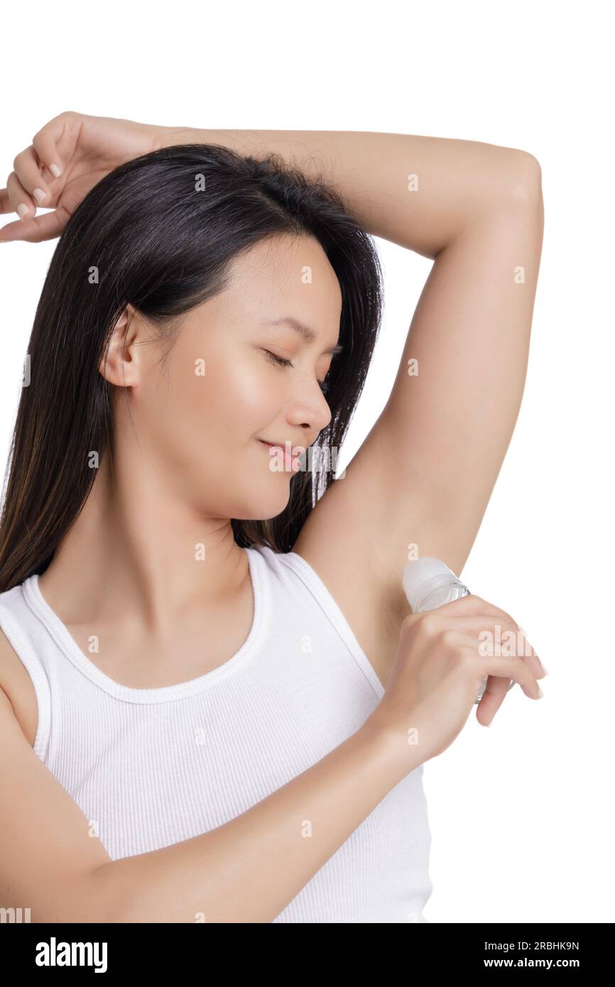 Wunderschöne Asiatin, die Deodorant für eine gute Körperhygiene aufträgt, isoliert auf weißem Hintergrund mit Kopierbereich Stockfoto