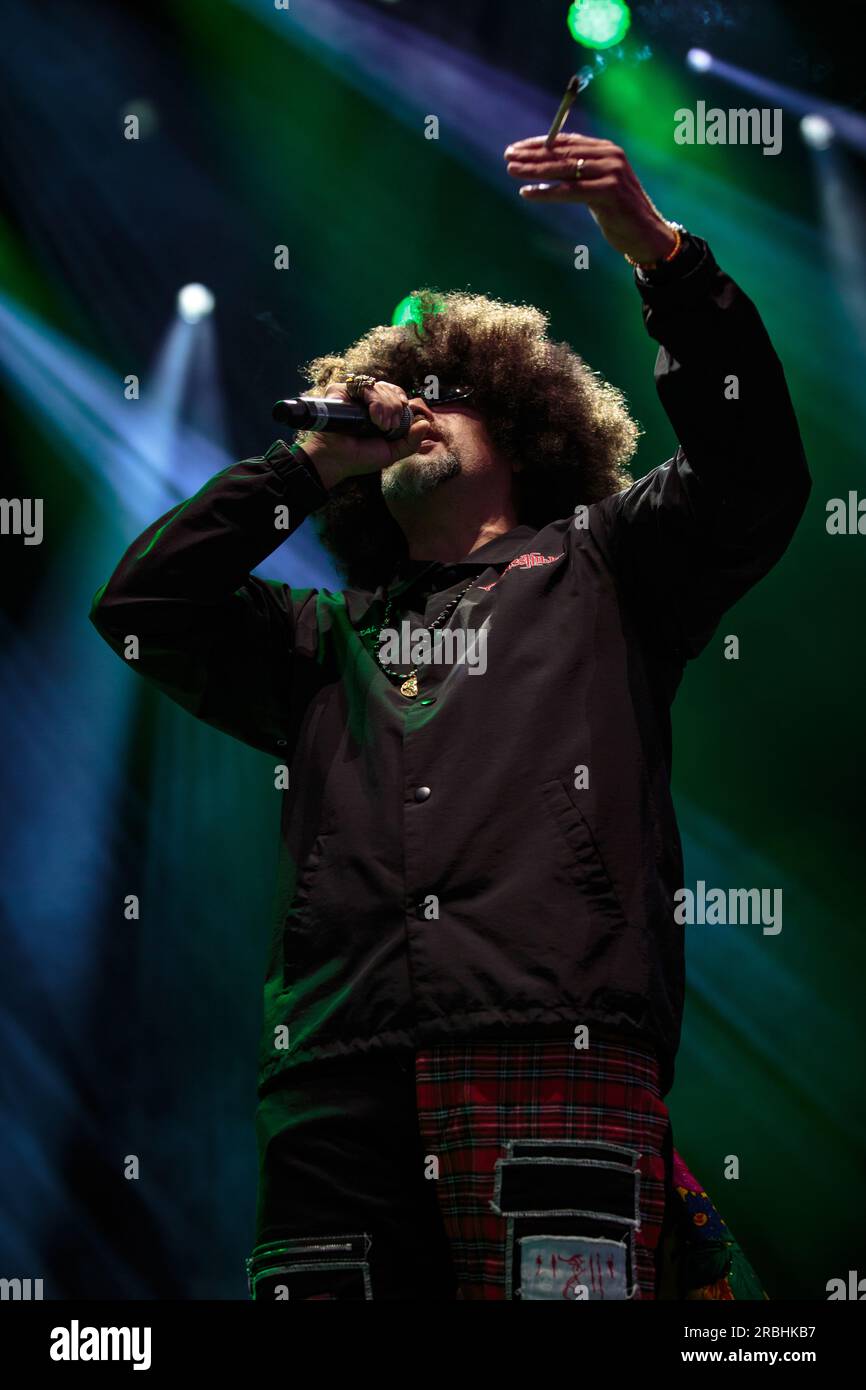 B-Real of Cypress Hill tritt auf der Bühne eine Sportsonnenbrille, einen großen Afro, schwarzen Trainingsanzug, ein Mikrofon und einen großen stumpfen Ton auf Stockfoto