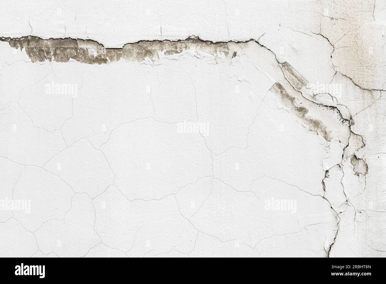 Alte weiße Zementwand mit komplexen Rissen und einzigartigen Mustern. Die raue Textur und der Hintergrund mit dem Kopierbereich. Stockfoto