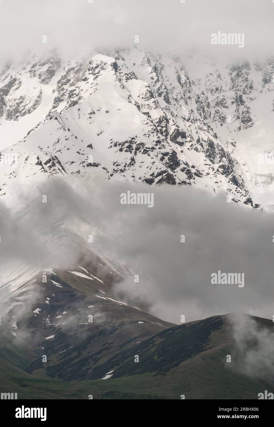 Schneebedeckte Berge und grüne Bergkämme in den Wolken, Georgia Stockfoto