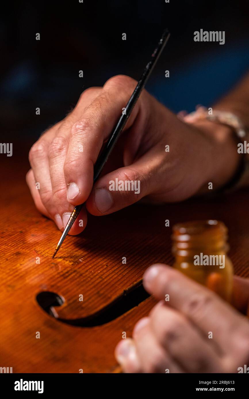 Violinmacher, der in seiner Werkstatt arbeitet - Holzarbeiten - Handwerker - Künstler Stockfoto