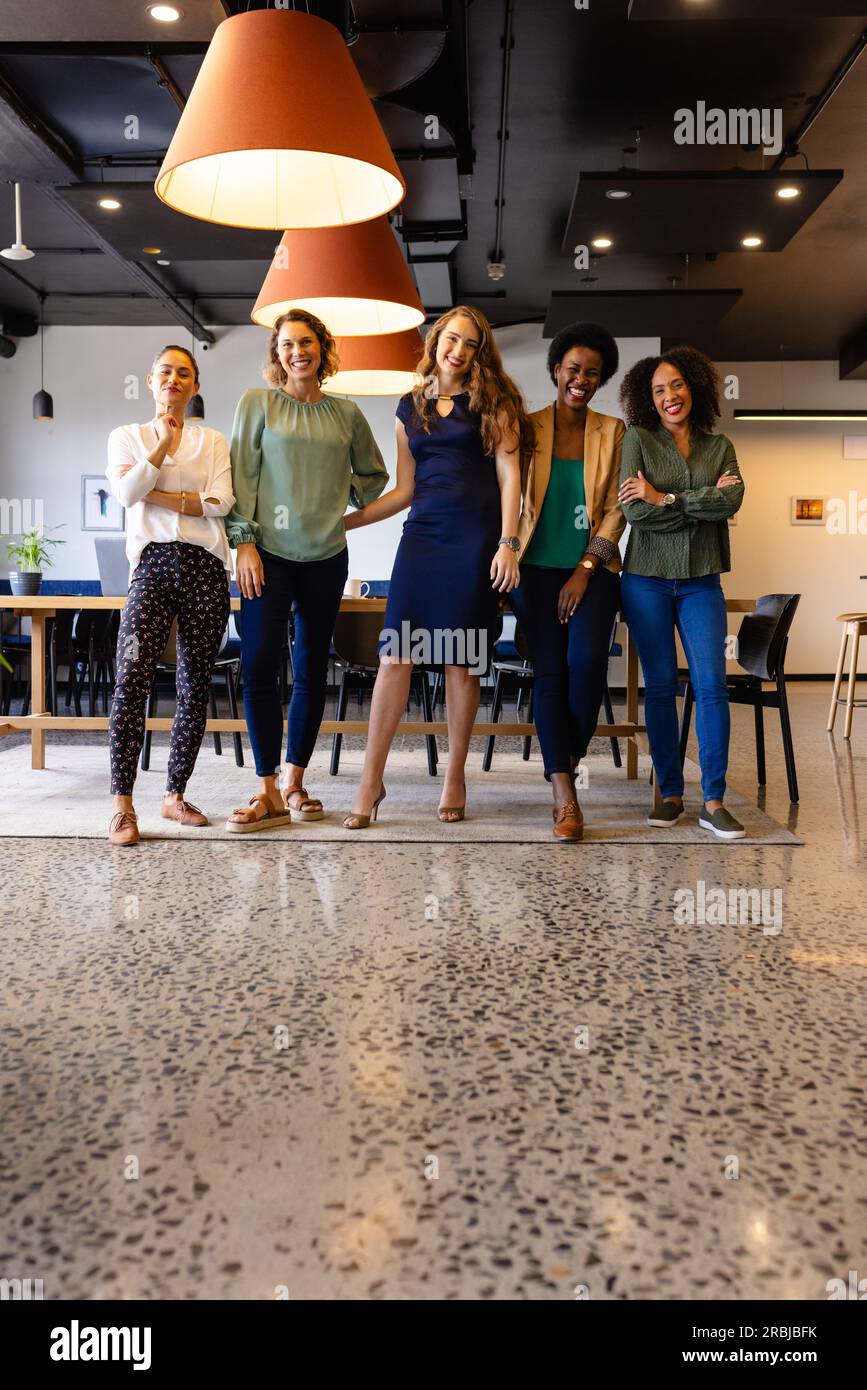 Portrait von glücklichen, vielfältigen weiblichen Kollegen in einer zwanglosen Besprechung im Büro, in der Mittagspause, im Kopierbereich. Ungezwungenes Büro, Teamarbeit, Arbeit und Arbeit, unverändert. Stockfoto