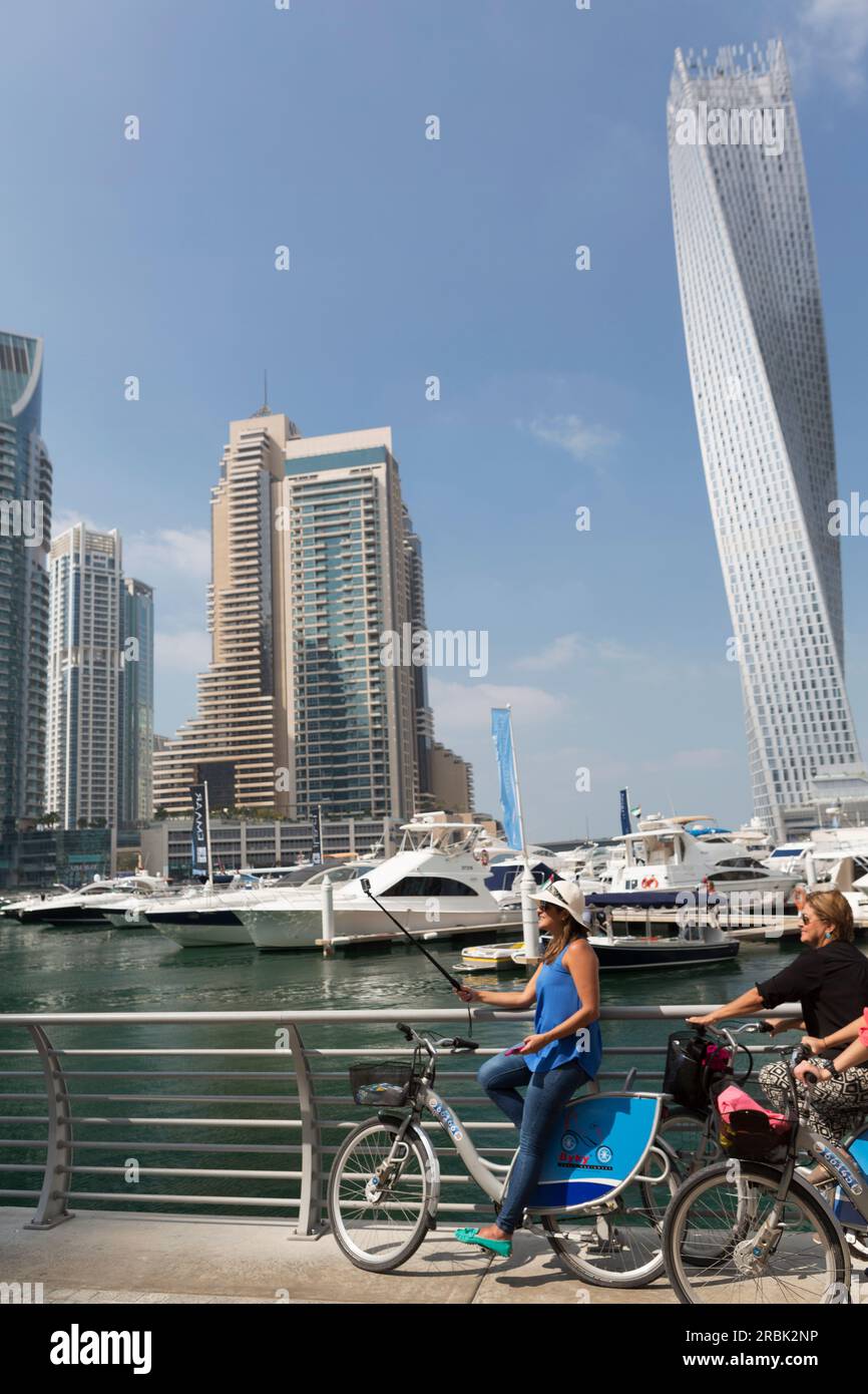 Vereinigte Arabische Emirate, Dubai, Touristen machen Selfie und der Cayan Tower im Hintergrund. Stockfoto