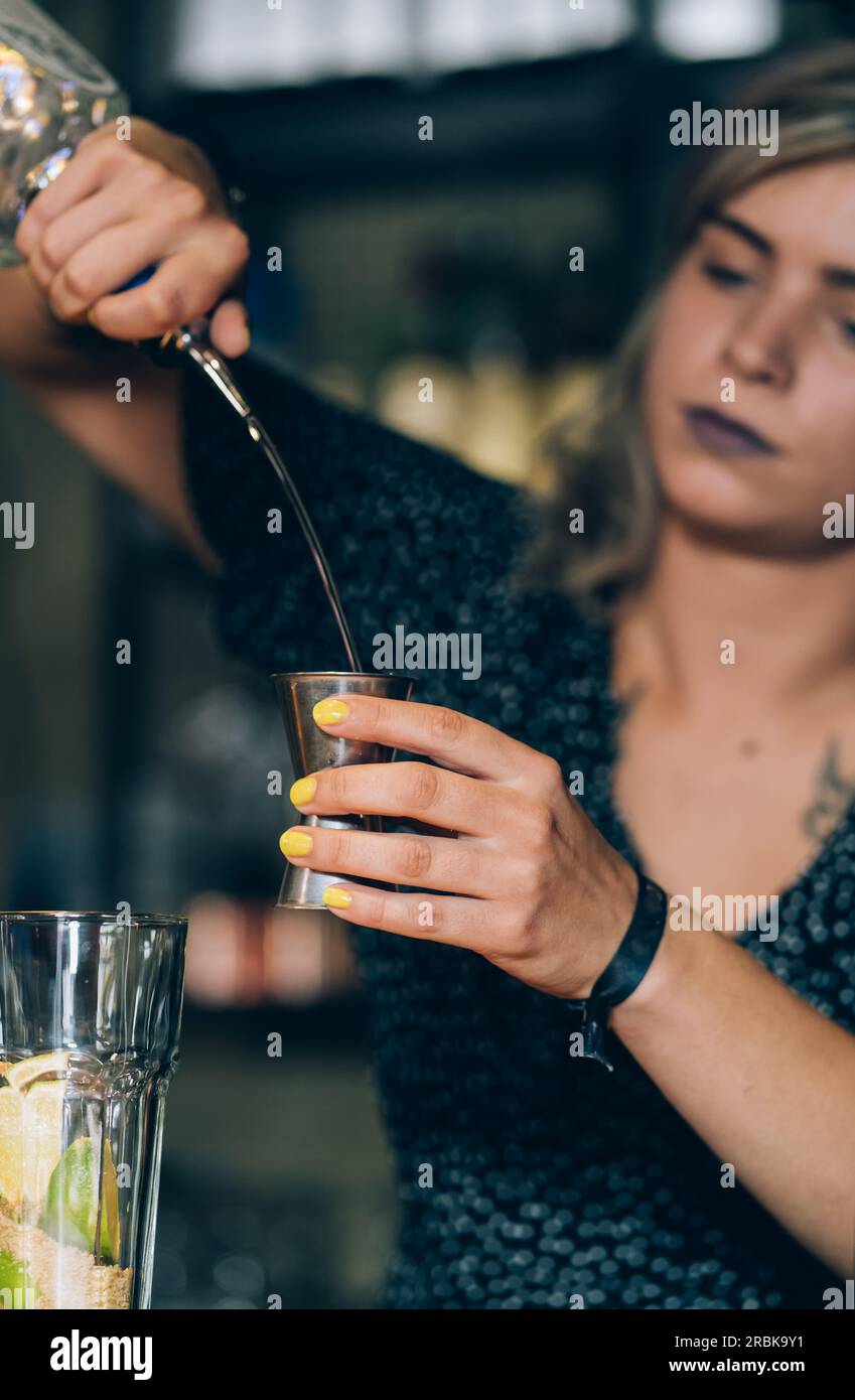 Eine Kellnerin mit Gelben Nägeln bereitet Einen Mojito-Cocktail in Einer Bar zu. Stockfoto
