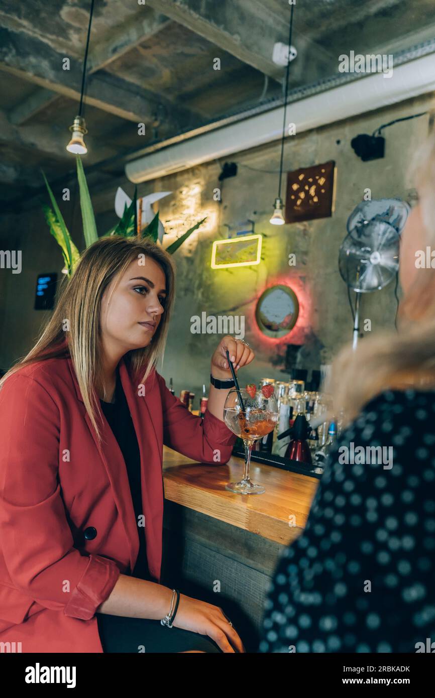 Blonde Girl spricht mit ihrem Freund in Einer Cocktailbar. Stockfoto