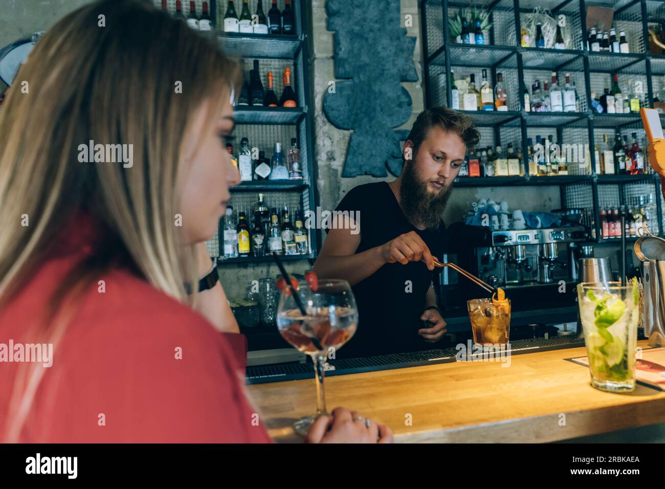Blonde Girl und Barkeeper in Einer Cocktailbar. Stockfoto