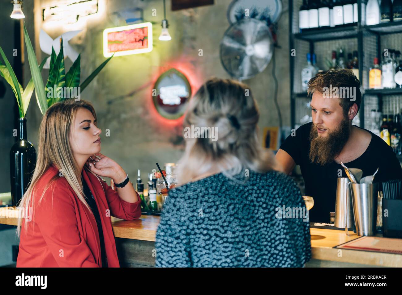 Freunde trinken Einen Drink in Einer Bar neben dem Barkeeper. Stockfoto