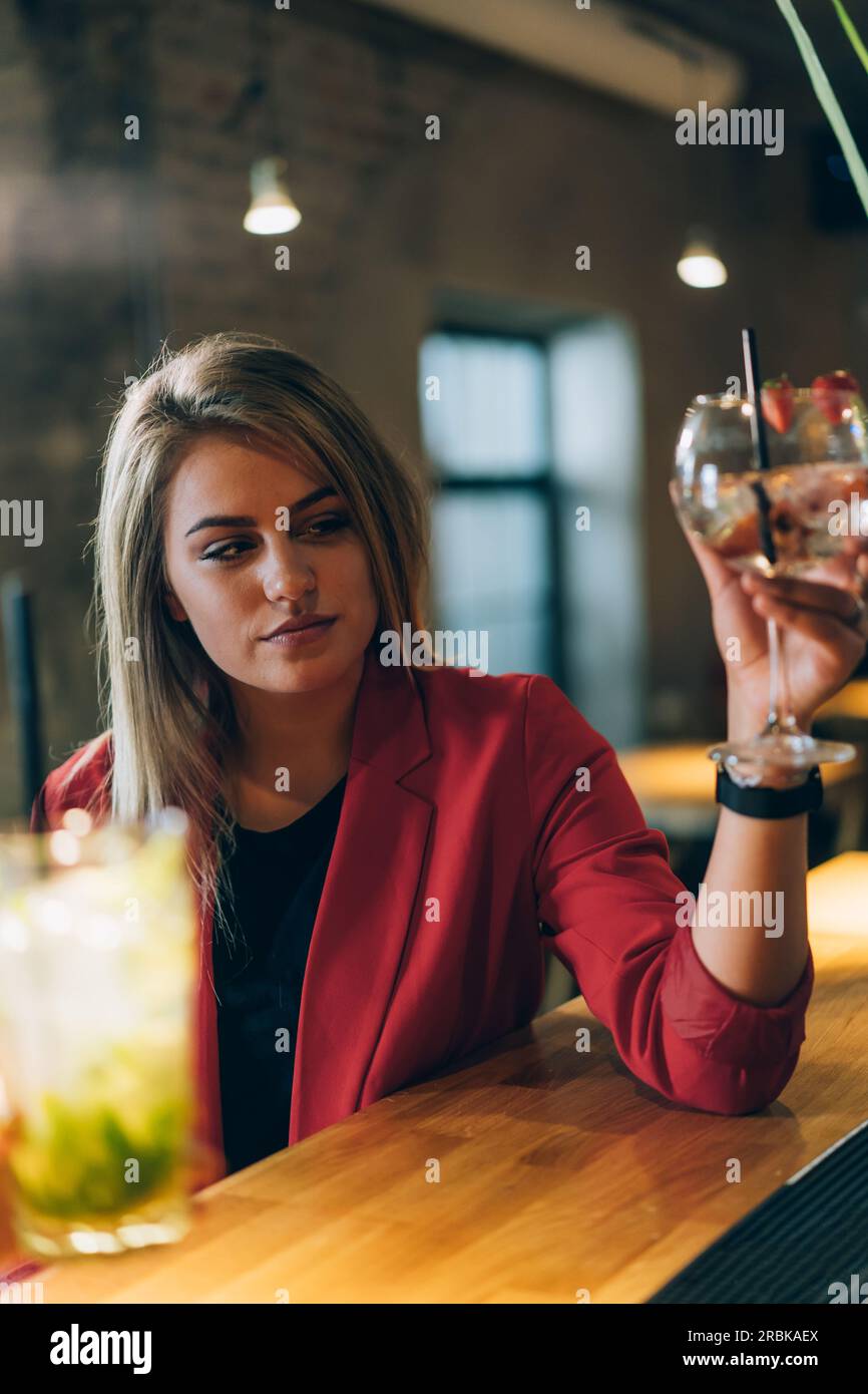 Blonde Girl Schaut Auf Ihre Cocktailbar. Stockfoto