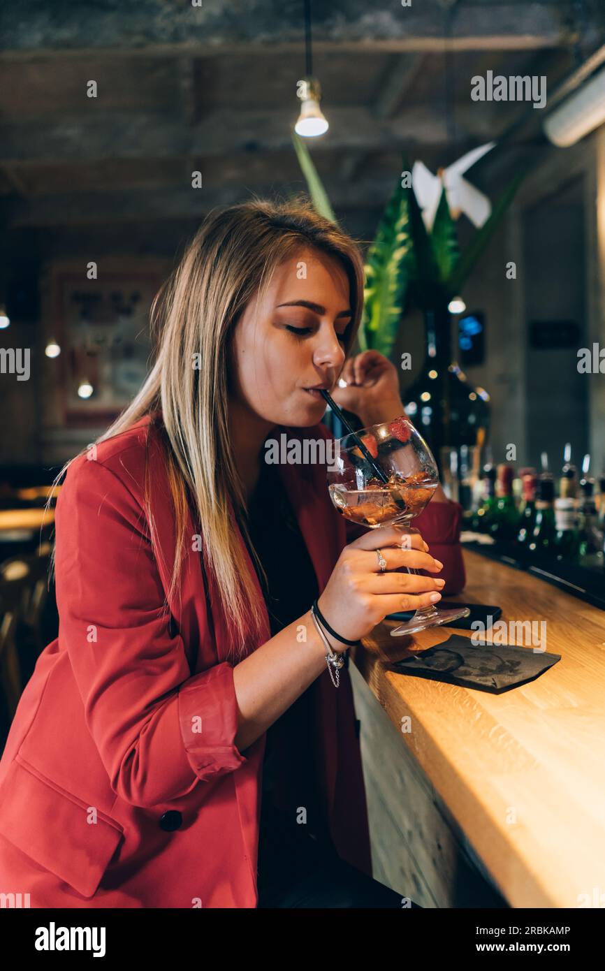 Blonde Girl trinkt Einen Cocktail in Einer Bar. Stockfoto