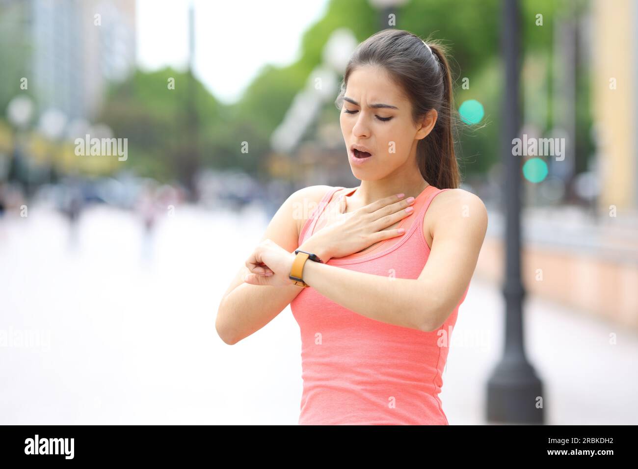 Läufer erstickt und Pulsationen auf Smartwatch nach Soprt auf der Straße prüfen Stockfoto