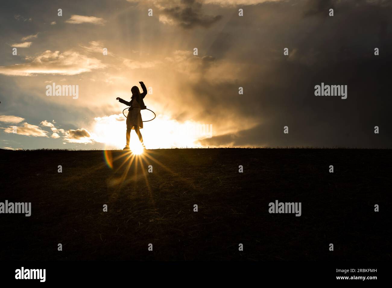 Silhouette des 9 Jahre alten Hoola-Hooping Stockfoto
