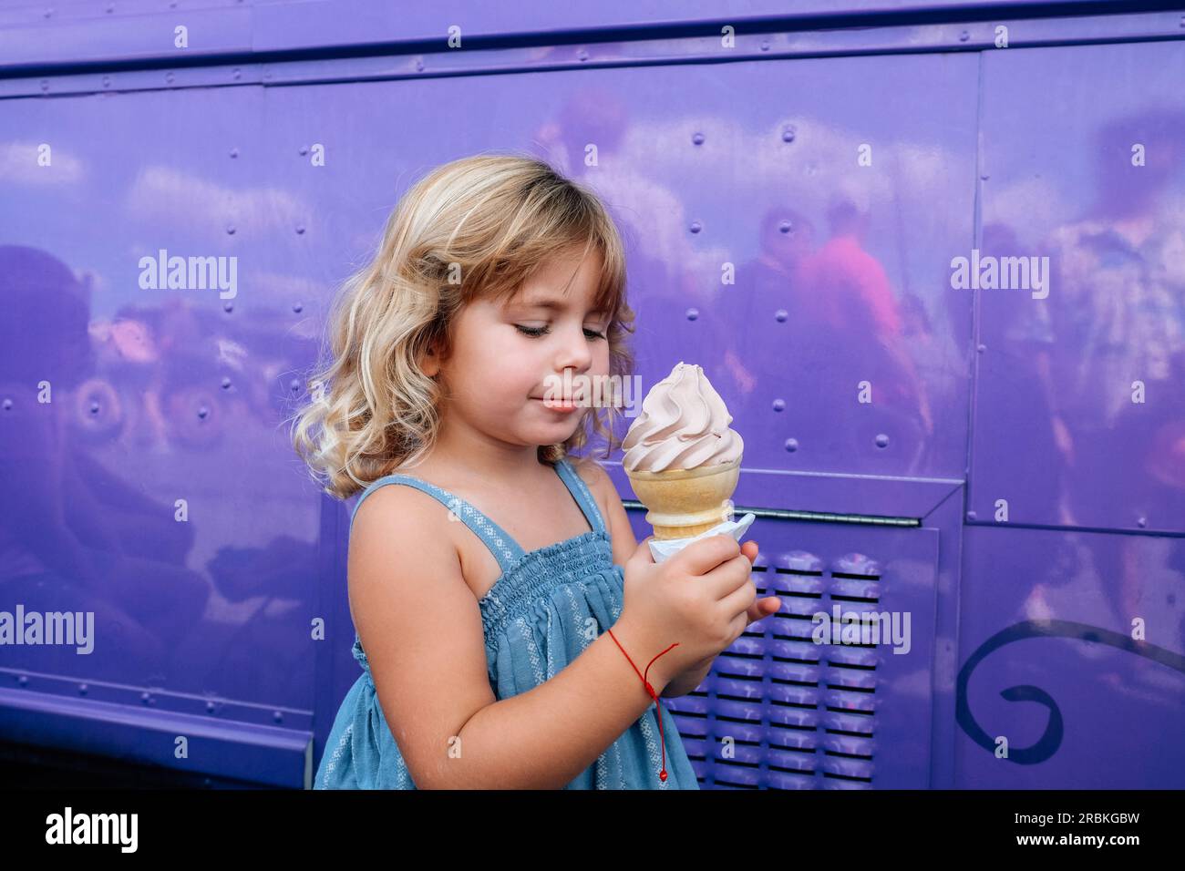 Ein kleines Mädchen, das sich darauf vorbereitet, Eis auf einer Zwiebel zu essen Stockfoto