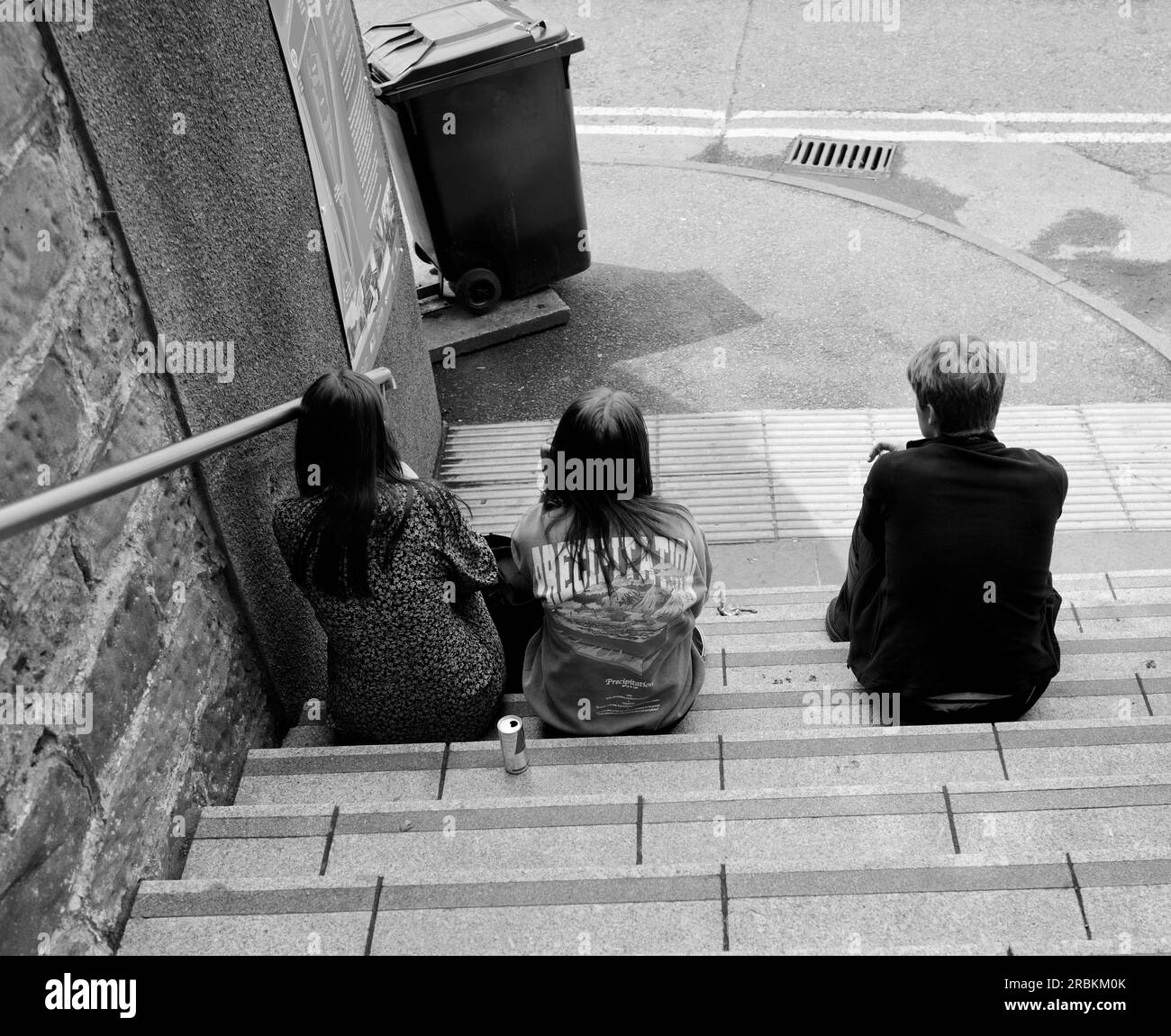 Drei Freunde sitzen auf den Stufen in Inverness Scotland Stockfoto