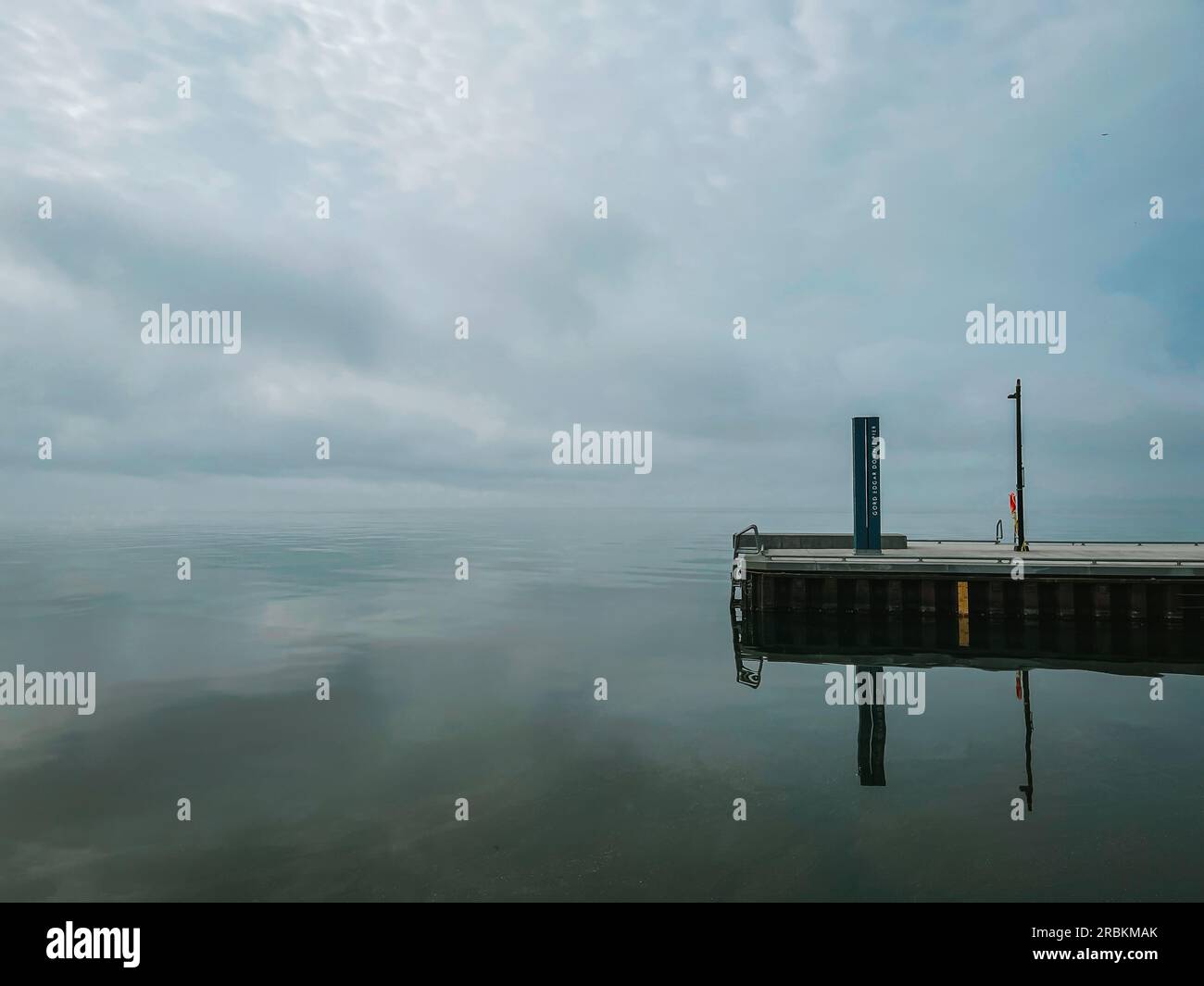 Leerer Pier am stillen See in Kingston, Ontario an bewölktem Tag. Stockfoto