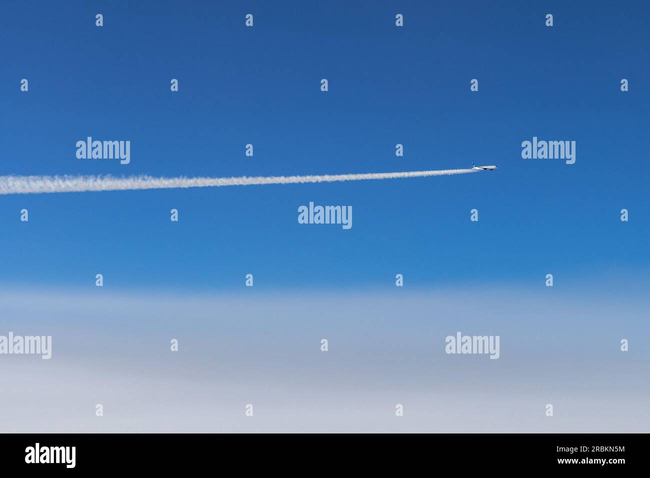 Flugzeug in 10,000 m Höhe mit Kondensationswegen, Luftaufnahme Stockfoto