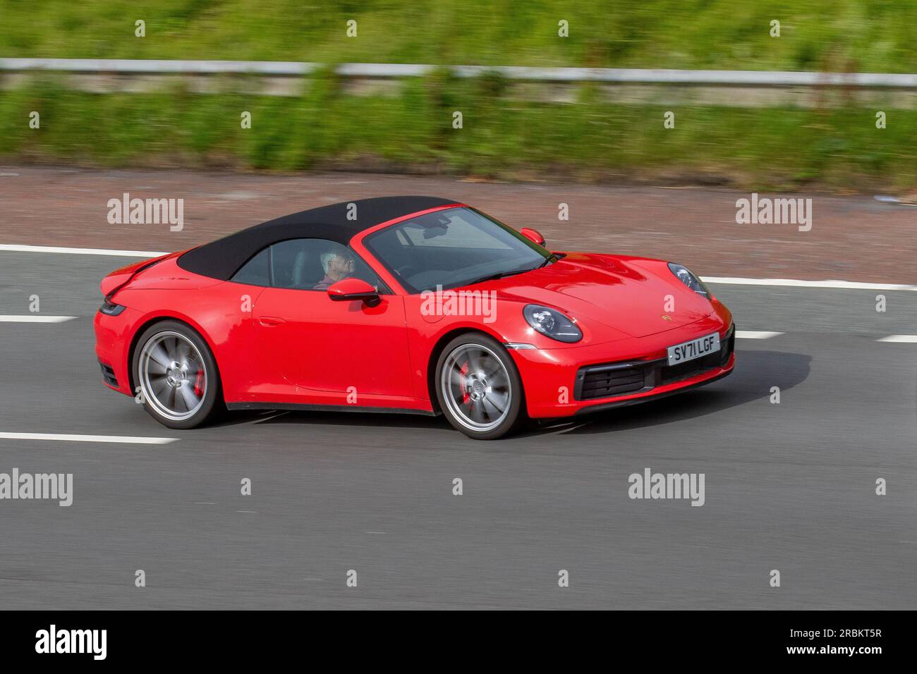 2021 Red Porsche 911 Carrera 4S Cabrio, T 450 4S Start/Stop Red Benzin Cabriolet Car 2981 cc; Fahrt mit hoher Geschwindigkeit auf der Autobahn M6 im Großraum Manchester, Großbritannien Stockfoto