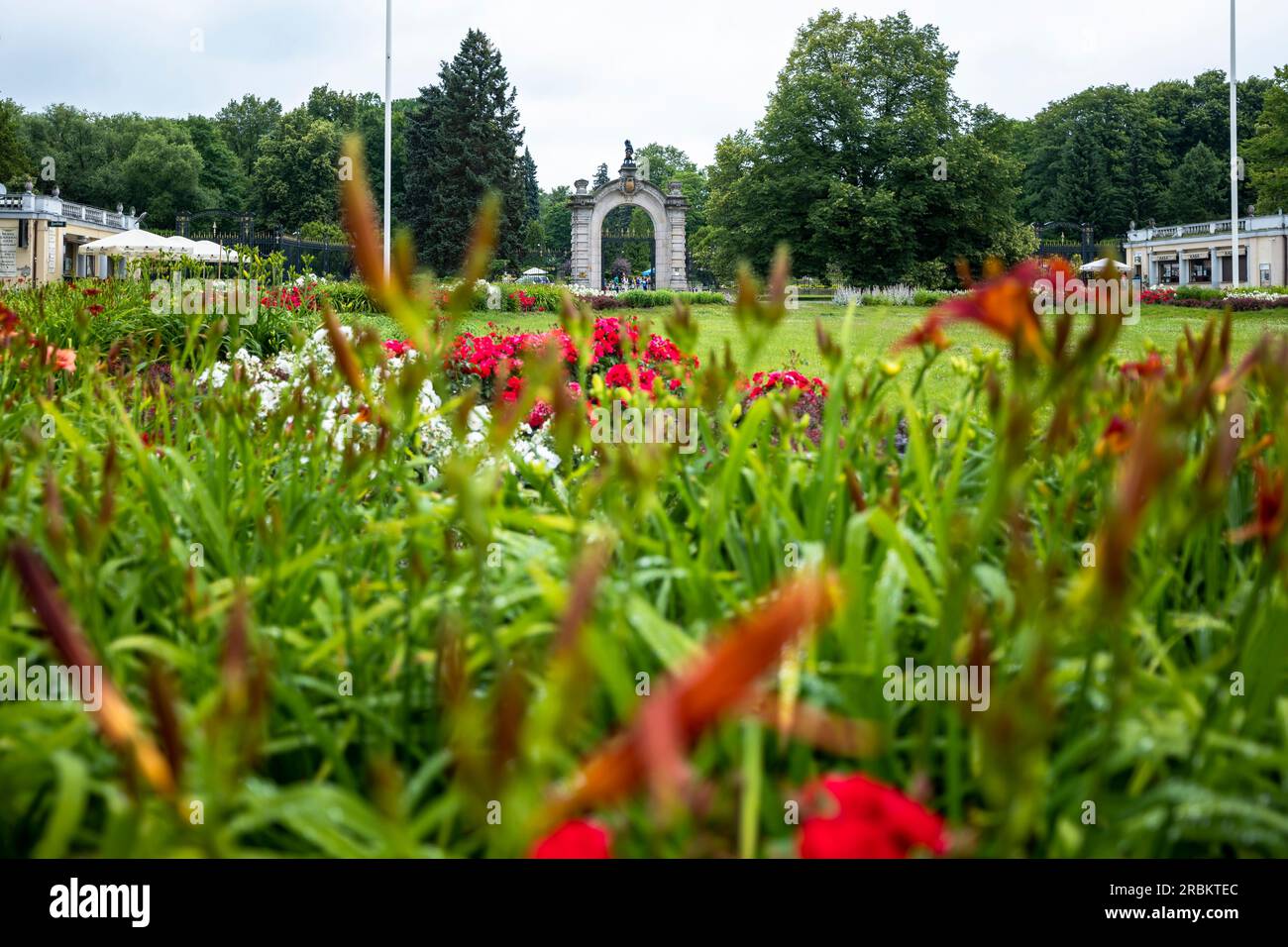 Chorzow, Polen - 29. Juni 2023: Das monumentale Haupttor zum Zoo. Pflanzen im Vordergrund unscharf. Stockfoto