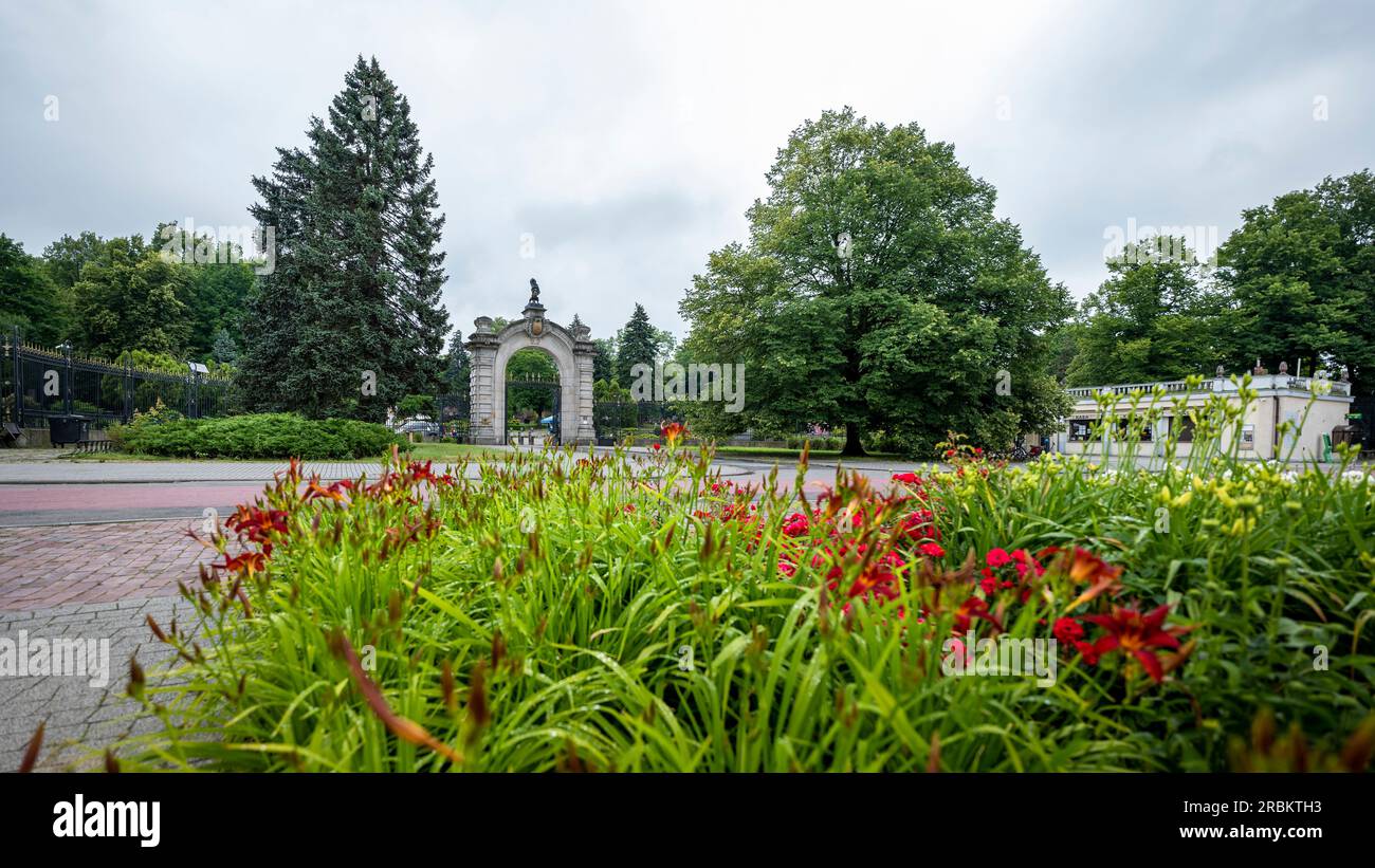 Chorzow, Polen - 29. Juni 2023: Das monumentale Haupttor zum Zoo. Pflanzen im Vordergrund unscharf. Stockfoto