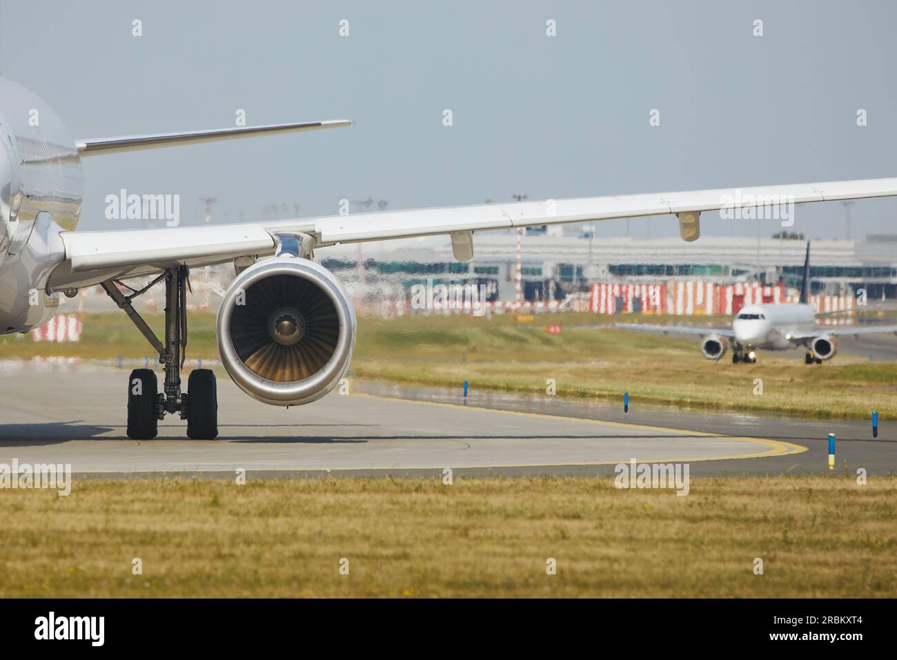 Heiße Luft hinter dem Triebwerk des Flugzeugs am Flughafen. Das Flugzeug fährt während des sonnigen Sommertags zur Startbahn. Stockfoto