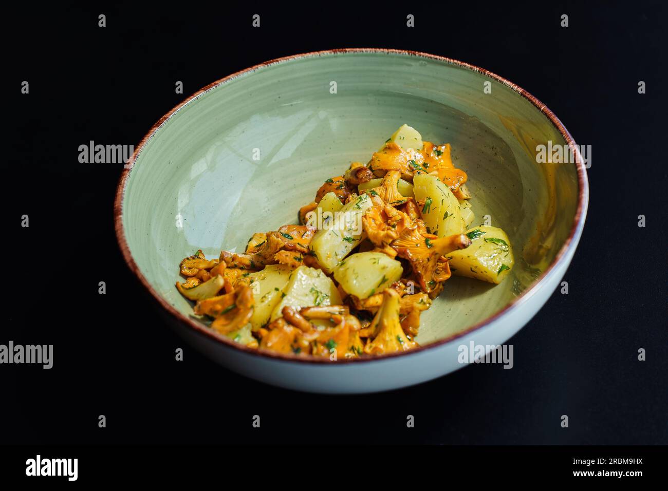 Wilde Pfifferling-Pilze mit gekochten Kartoffeln und Kräutern. Ein köstliches vegetarisches Mittagessen mit saisonalen Zutaten. Stockfoto