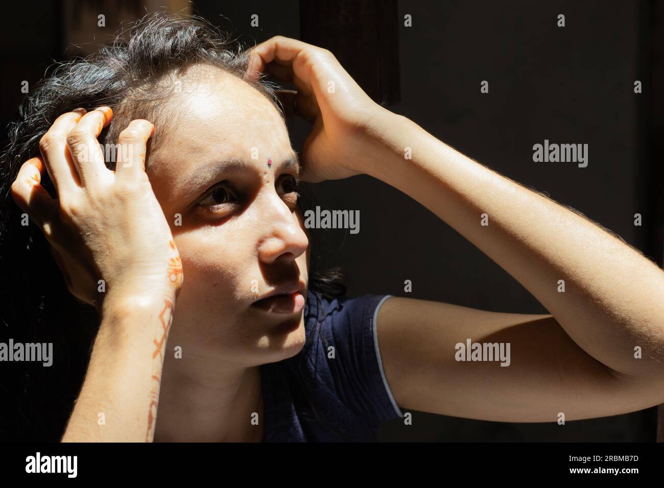 Wunderschönes indisches Modell mit dramatischem dunklen Licht und Schatten, die in den Himmel blicken. Stockfoto