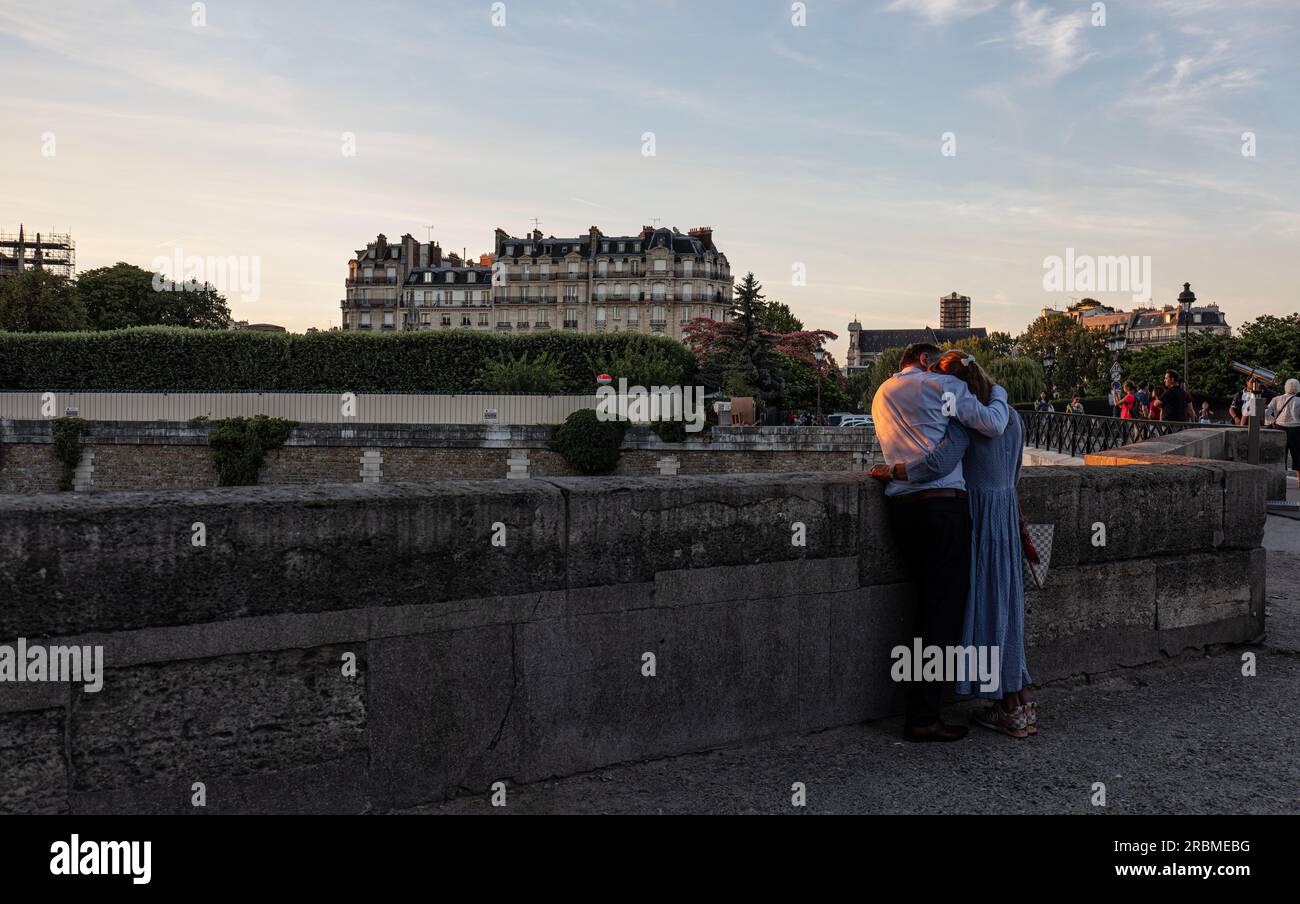 Romantisches Paris. Mann-Frau-Paar am linken Ufer bei Sonnenuntergang Blick auf die seine an der Pont de l'Archevêché mit der Ile de la Cite im Hintergrund. Paris. Stockfoto