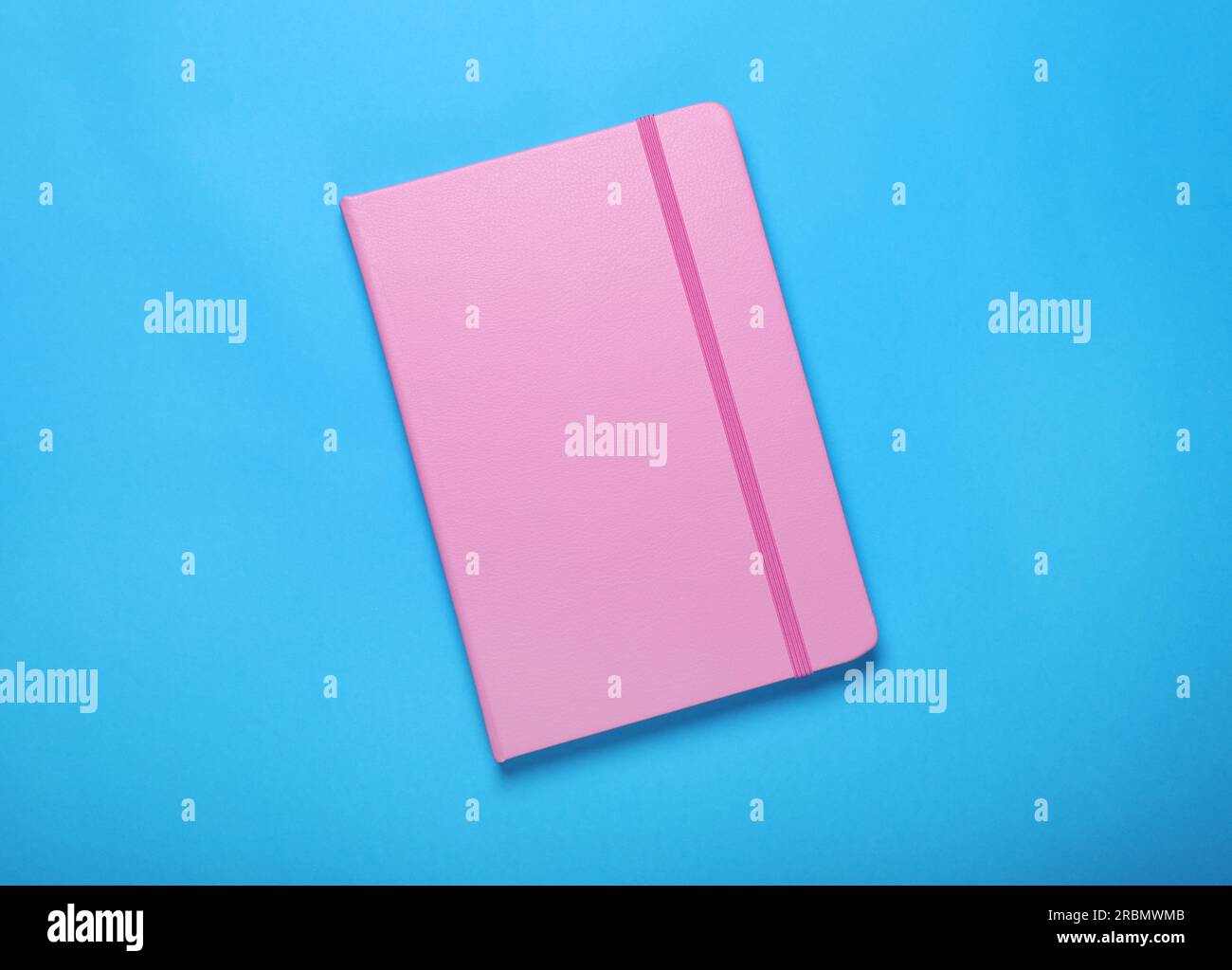 Rosafarbenes Notizbuch auf hellblauem Hintergrund, Draufsicht Stockfoto