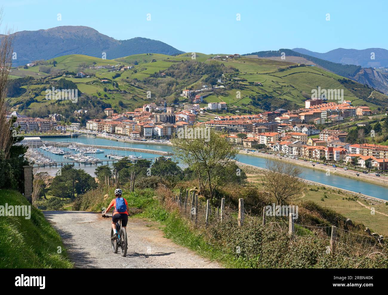 Nette ältere Frau, die mit ihrem elektrischen Mountainbike in den Hügeln über Zarautz, Baskenland, Spanien, radelt Stockfoto