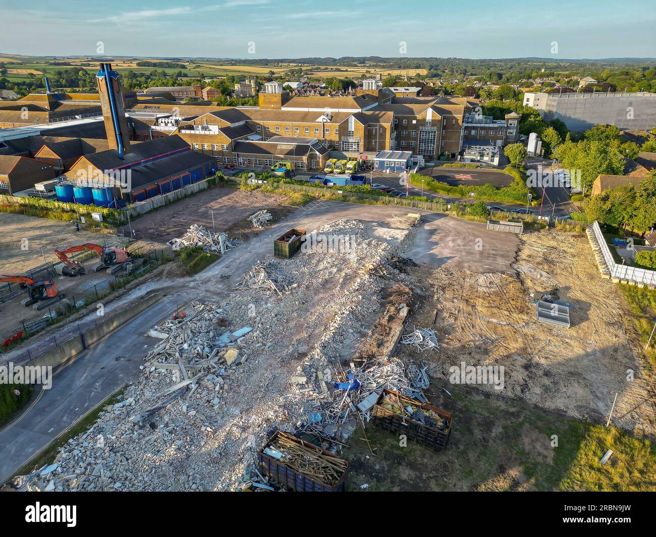 Dorchester, Dorset, Großbritannien. 9. Juli 2023 Blick aus der Luft auf den Abriss der ehemaligen Damers First School neben dem NHS Dorset County Hospital in Dorchester in Dorset. Der Standort wird für den Bau einer neuen Notaufnahme (ED) und Intensivstation vorbereitet, die Teil des neuen Krankenhausprogramms der Regierung ist, in dem bis 2030 40 neue Krankenhäuser gebaut werden. Bildnachweis: Graham Hunt/Alamy Live News Stockfoto