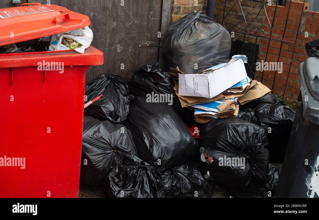 Slough, Berkshire, Großbritannien. 10. Juli 2023. Slough Borough Council hat kürzlich eine Änderung der Mülltonnen der Bewohner eingeführt, um die Bewohner zu ermutigen, mehr zu recyceln. Graue Abfallbehälter mit allgemeinen Abfällen, einschließlich Lebensmitteln, werden nun alle zwei Wochen anstatt einmal pro Woche gesammelt. Das Recycling erfolgt in roten Abfallbehältern, die in der abwechselnden Woche gesammelt werden. Obwohl es in Chalvey, Slough, einen kostenlosen Ratsheiztipp für Einwohner gibt, hat die Stadt bereits ein großes Problem mit Müll und Fliegenkippen. Kredit: Maureen McLean/Alamy Live News Stockfoto