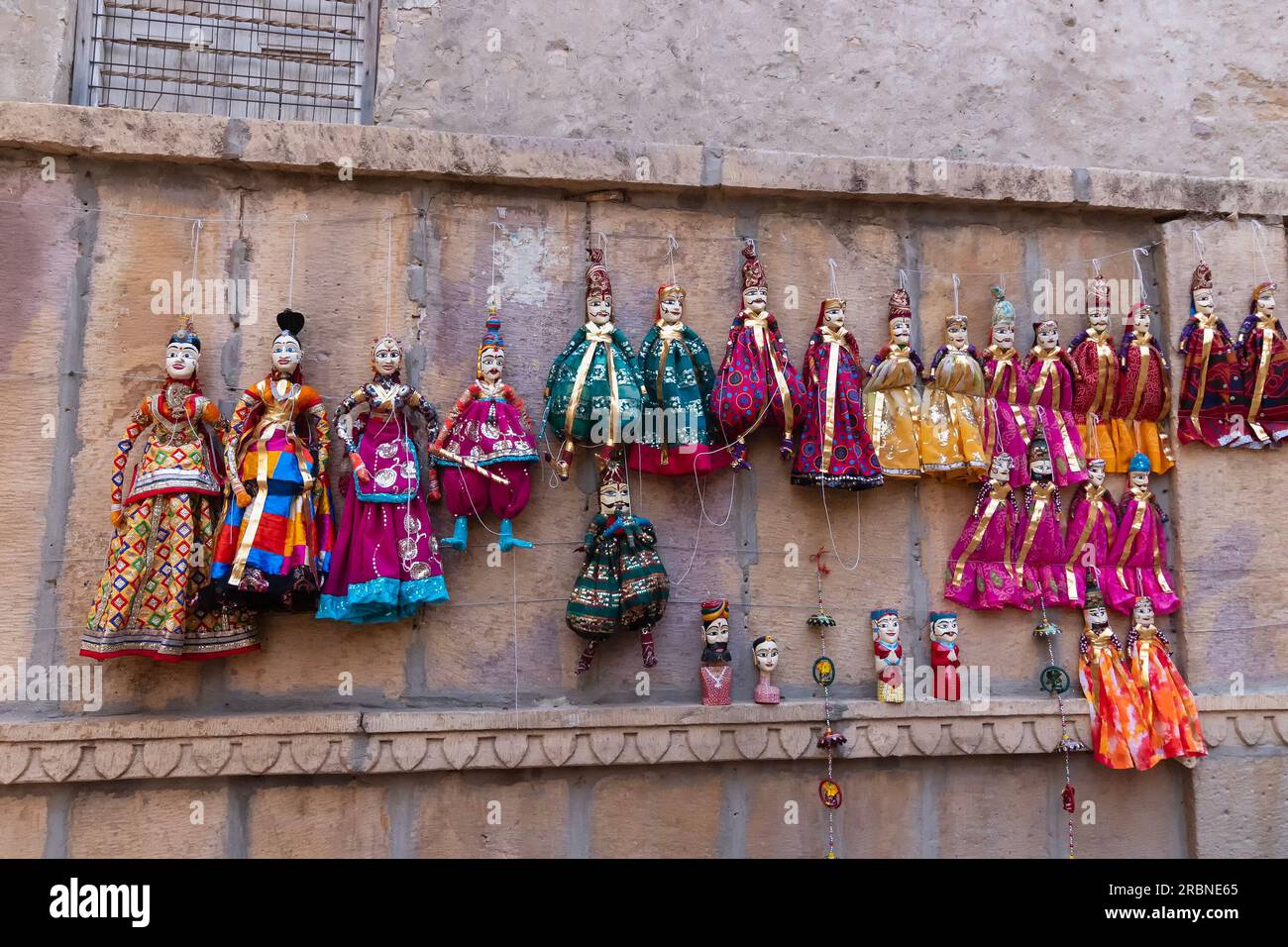 Jaisalmer, Rajasthan, Indien - 16. Oktober 2019 : traditionelle Rajasthani Raja Rani Puppen, die in der Nähe von Patwon Ki Haveli an der Wand hängen. Stockfoto