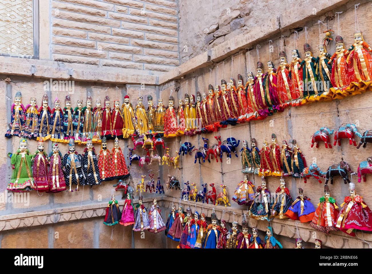 Jaisalmer, Rajasthan, Indien - 16. Oktober 2019 : traditionelle Rajasthani Raja Rani Puppen, die in der Nähe von Patwon Ki Haveli an der Wand hängen. Stockfoto