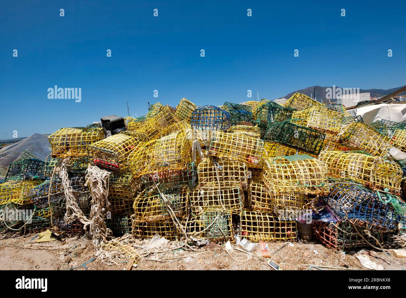 Ein Stapel von farbenfrohen Hummern und Krabbentöpfen oder Körben aus Plastik, die von Fischern am Hafen Estepona, Spanien, zum Trocknen gelassen wurden Stockfoto