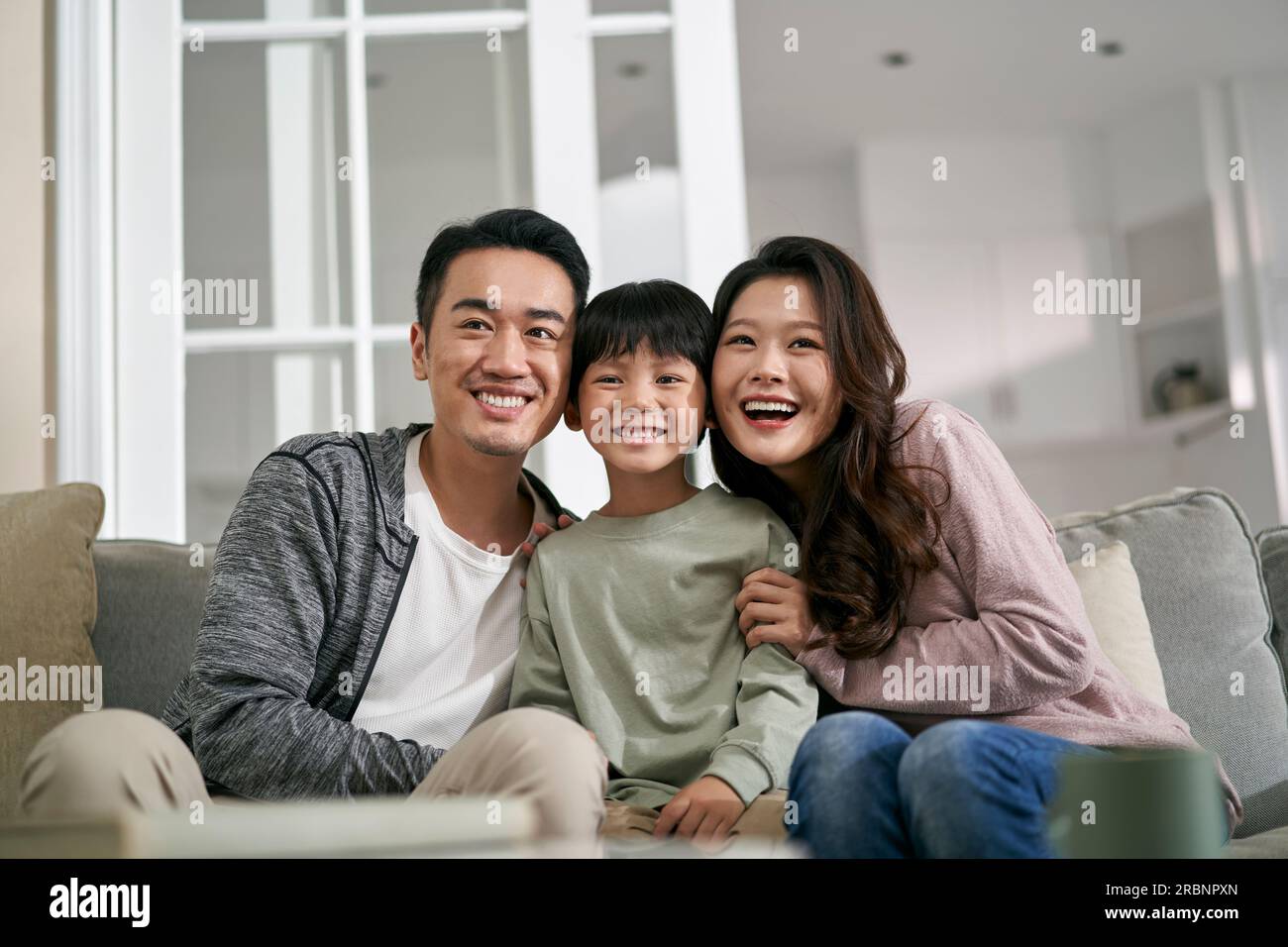 Junge asiatische Familie mit einem Kind, die sich zu Hause amüsiert Stockfoto