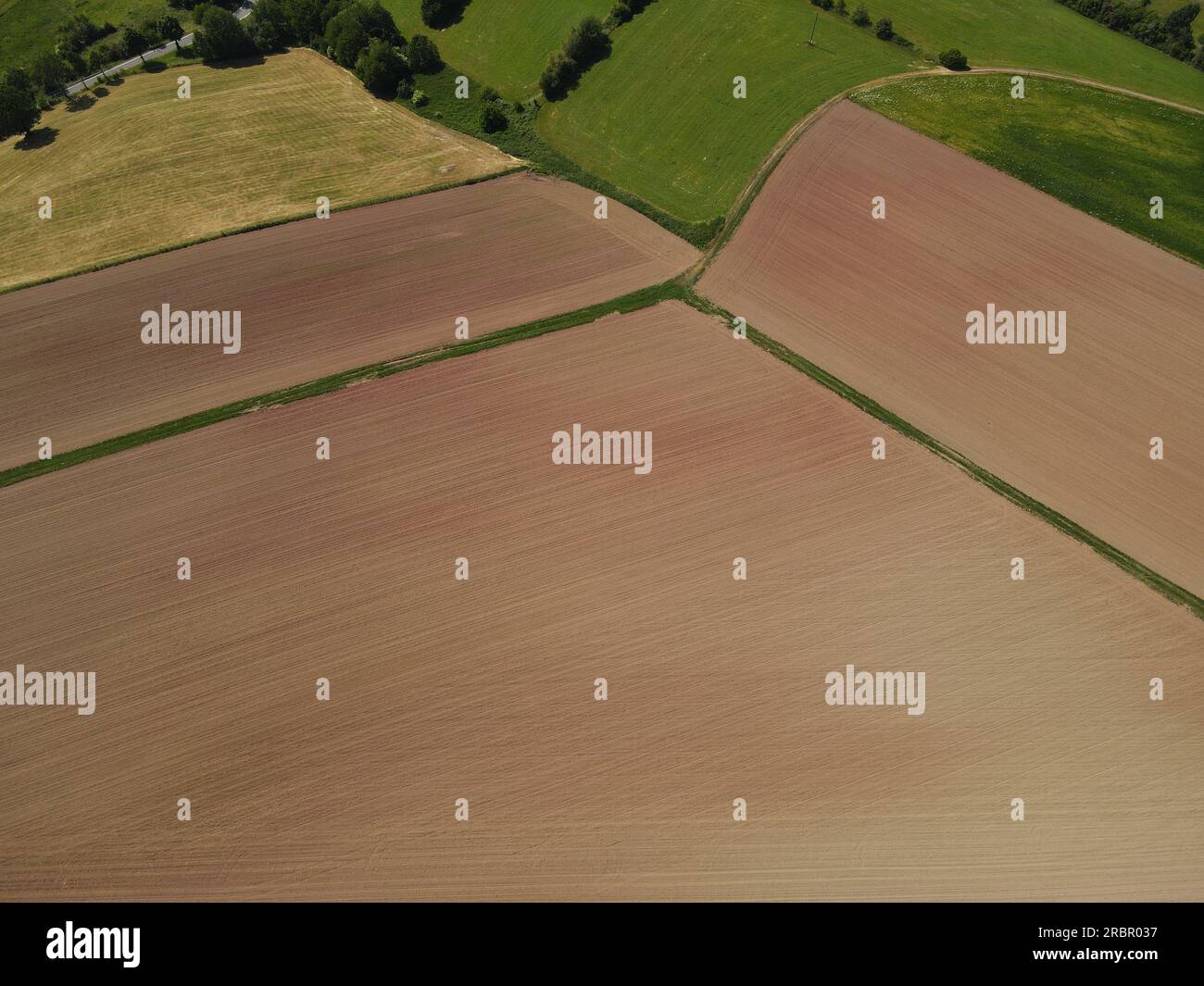 Landwirtschaftliche Felder mit braunem Pflügen von oben im Sommer Stockfoto