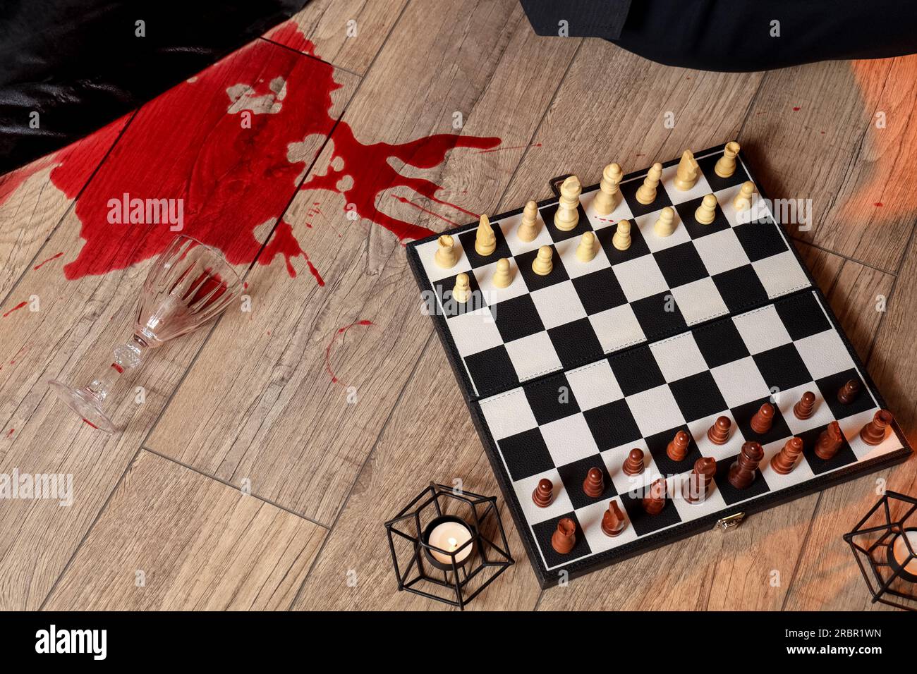 Schachbrett mit Kerzen und Wein auf dem Boden Stockfoto