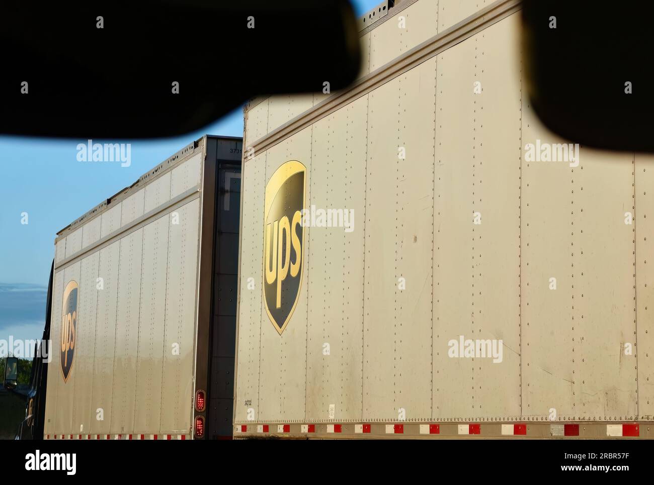 Nahaufnahme aus der Nähe eines Autos, das an einem UPS-Kurierwagen mit zwei Anhängern auf der Interstate 5 Oregon USA vorbeifährt Stockfoto