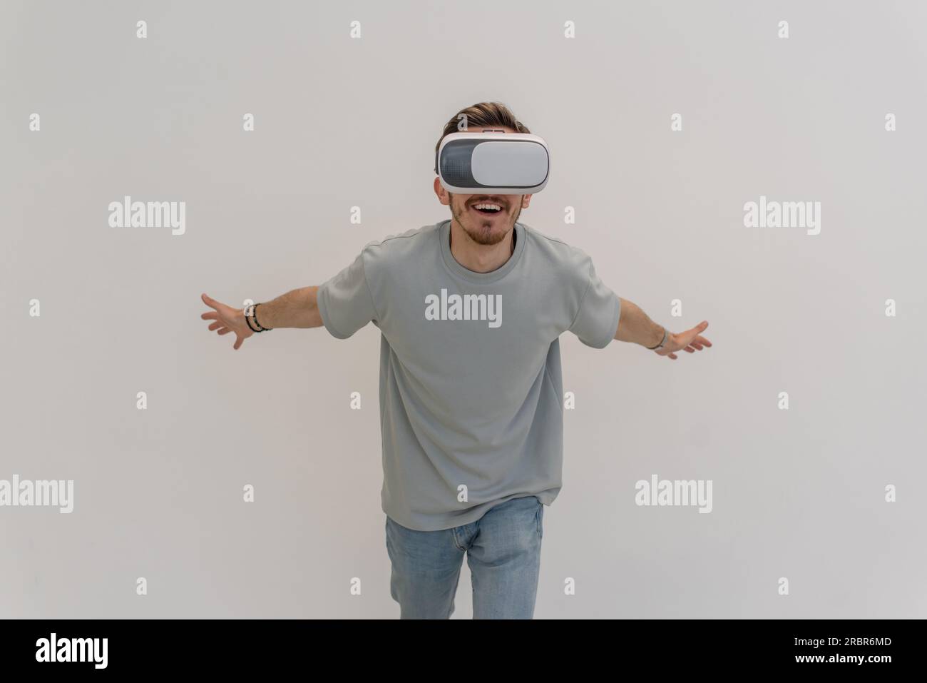 Futuristischer Mann mit Virtual-Reality-Brille interagiert mit der Luft auf einem isolierten grauen Hintergrund. Stockfoto
