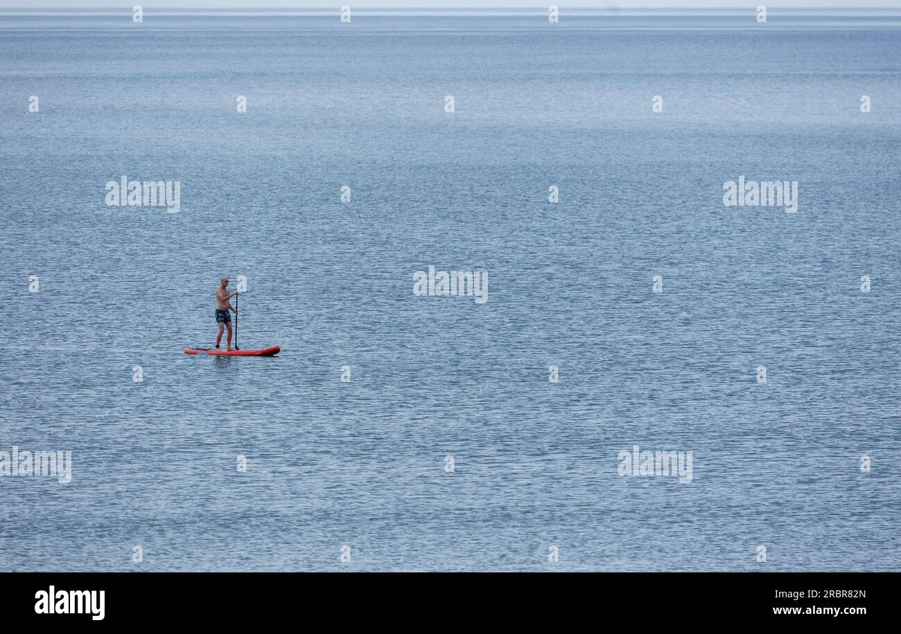 Barmouth, wales, 14. juni 2023 Stand-up Paddle Board Mann Paddleboarding auf blauem Wasser. Stockfoto