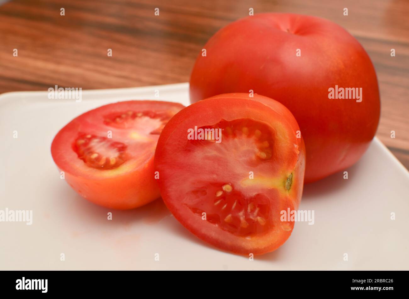 Nahaufnahme frischer roter Tomaten, perfekt, um Ihren Rezepten Farbe und Geschmack hinzuzufügen. Stockfoto