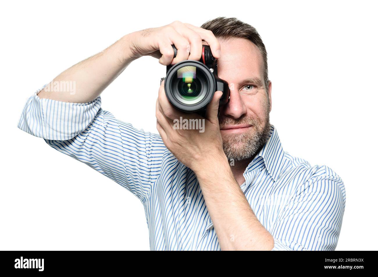 Männlicher Fotograf fokussiert und erstellt ein Bild mit seiner professionellen digitalen DSLR-Kamera, die das Objektiv direkt auf den Betrachter, den Oberkörper richtet Stockfoto