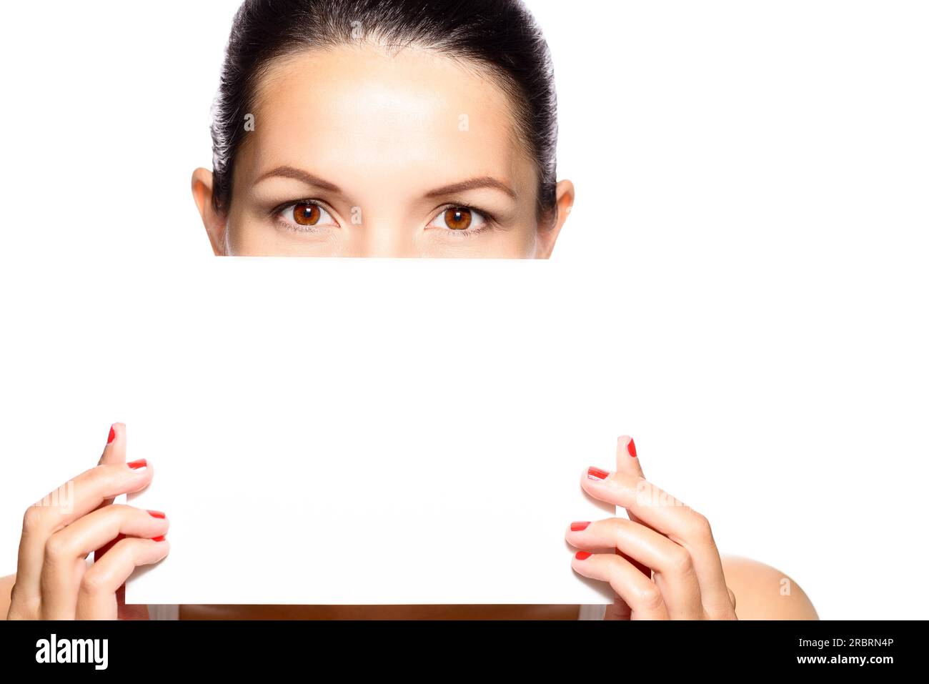 Eine Frau mit schönen Augen, die ein leeres weißes Schild hält, das die untere Hälfte ihres Gesichts, Kopf und Schultern verdeckt Stockfoto