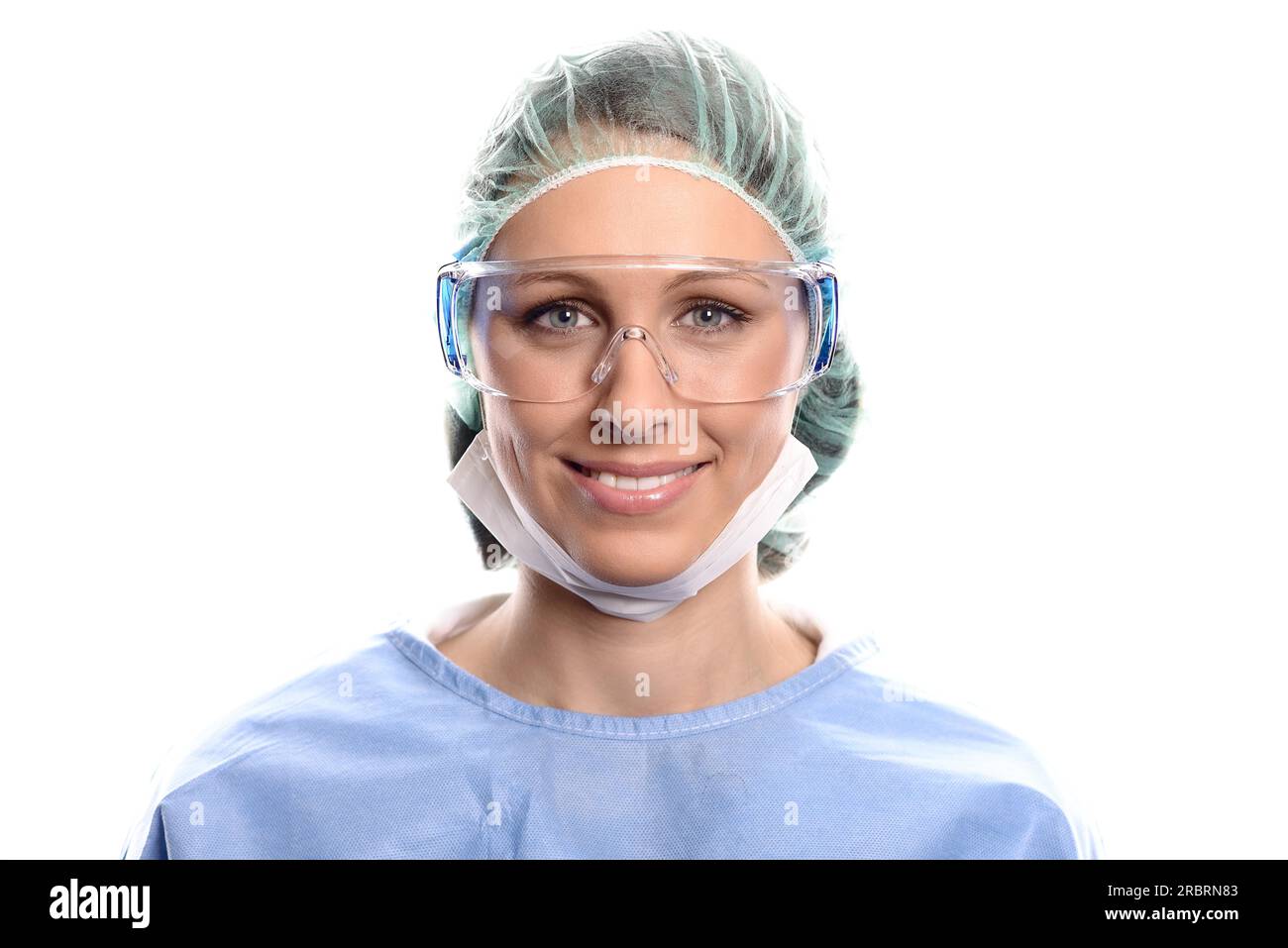 Junge Krankenschwester oder Ärztin in OP-OP-Kittel, Maske, Schutzbrille und eine Kappe, die direkt auf Kamera, Kopf und Schultern blickt Stockfoto