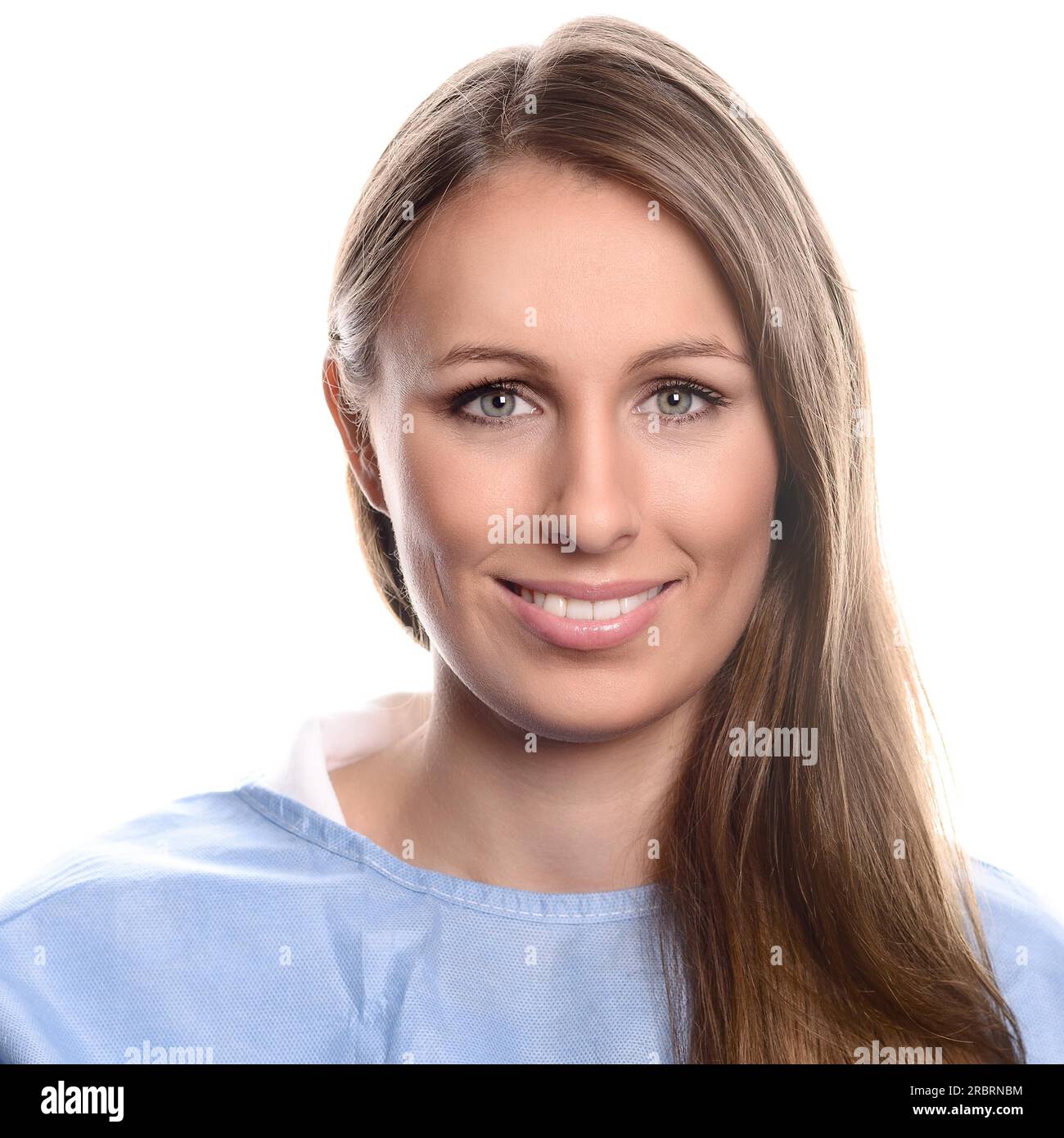 Porträt einer jungen und freundlichen Fachärztin, die in die Kamera schaut, mit blauen Augen und einem wunderschönen Lächeln, während sie blaue Medizin trägt Stockfoto